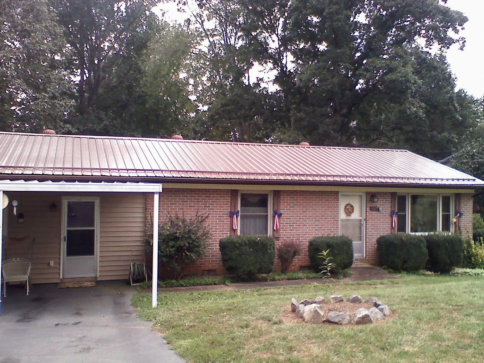 Bronze metal roof and carport on a brick ranch home — Roof Repair work by our crew in Wawaka