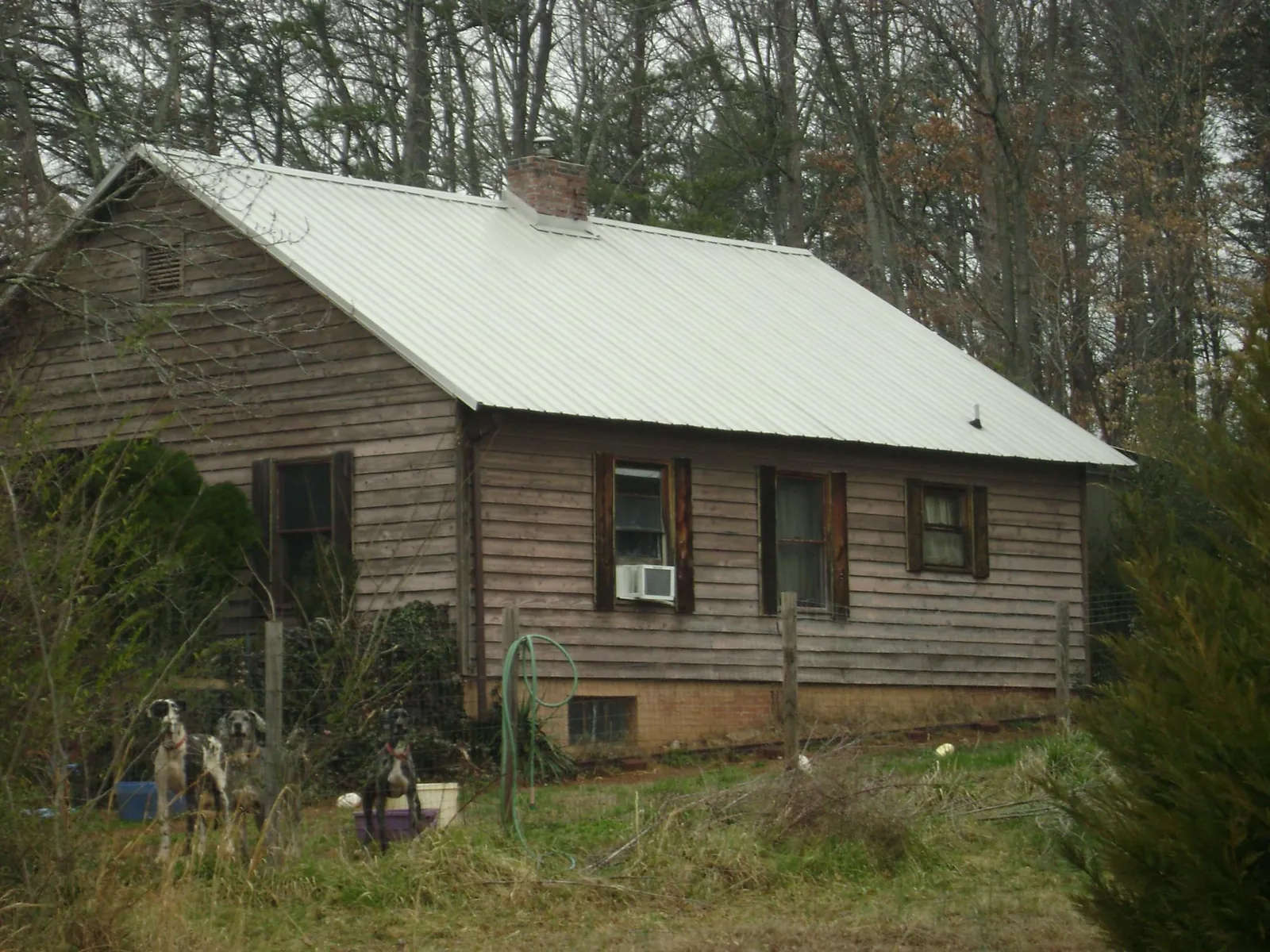 White metal roof on an old wood sided farmhouse, from a Metal Roof Installation job in Wawaka